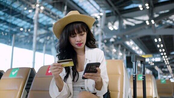 一名亚洲女性在机场候机时使用智能手机
