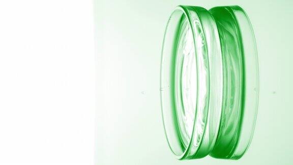 绿色的水滴在培养皿中与液体一起荡起涟漪