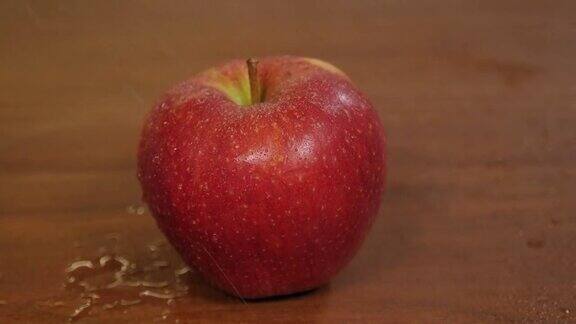 一个红苹果被喷上了水水滴慢慢地往下滴