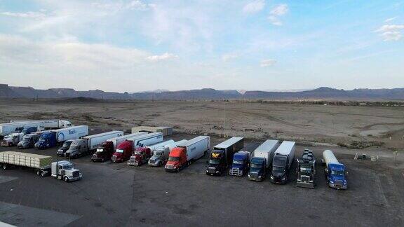 黄昏时分无人机将半卡车停在犹他州东部沙漠的一个大卡车站