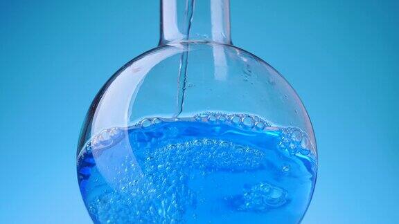 在实验室烧瓶中倒入蓝色液体溶液