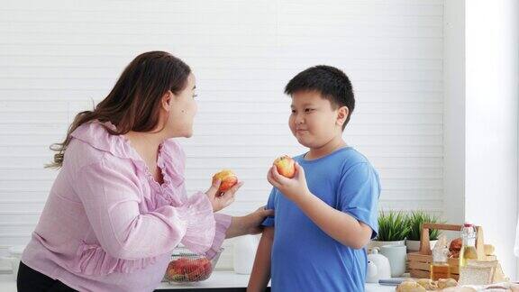 超重的妈妈和儿子吃一个新鲜的苹果有机营养维生素C饮食