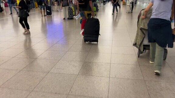 人们带着他们的旅行行李在机场办理登机手续时排队