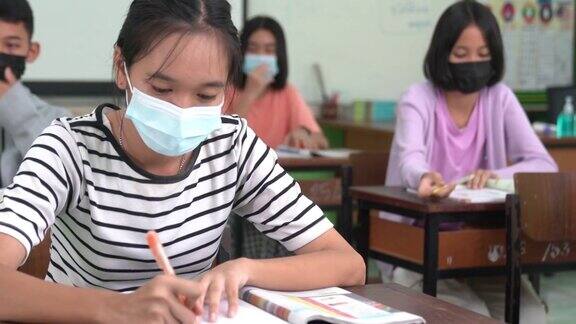 亚洲小学生戴上口罩预防病毒上课开始重开