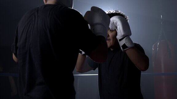 拳击运动员戴着手套在拳击场内与对手进行激烈的面对面格斗