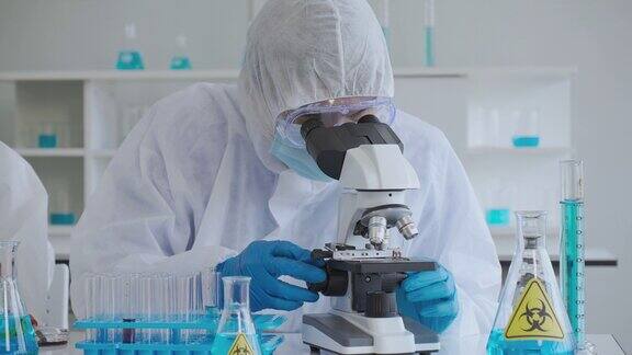 Covid-19:该小组的科学家在实验室使用显微镜进行研究