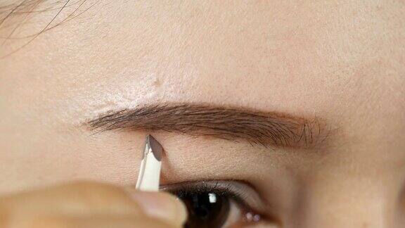 一个女人用镊子做一个形状的眉毛的4k特写