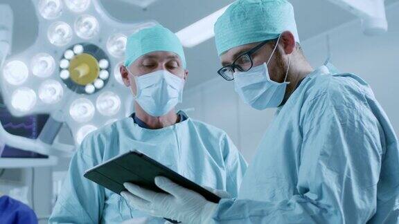 两名专业外科医生站在现代医院手术室里使用数字平板电脑