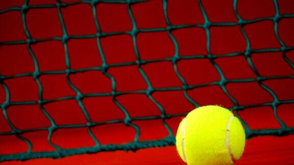 网球靠近网在红色地板4k
