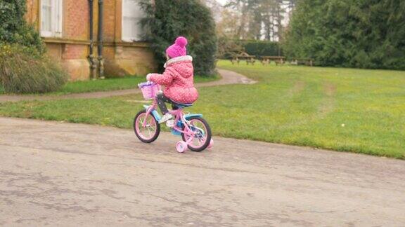 北爱尔兰冬季乡村公园里骑自行车的小女孩