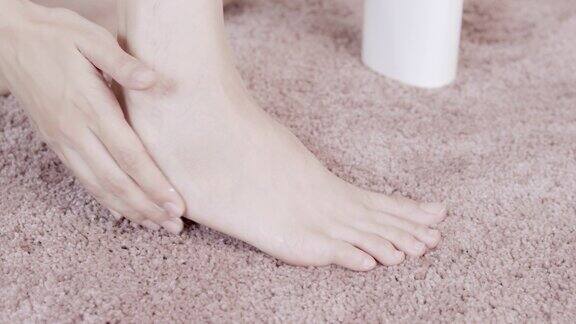 亚洲成年妇女用手在她的脚上涂抹保湿霜身体保健