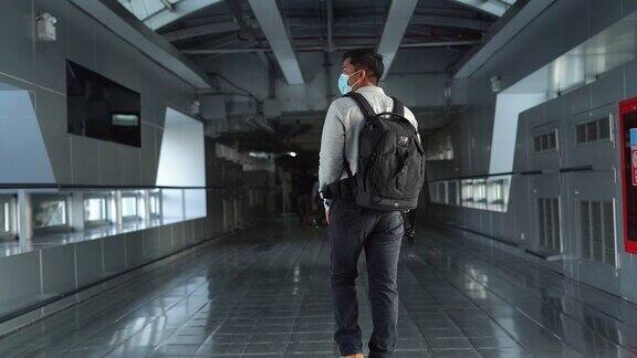 一名亚洲男子从航站楼走向机场检票口