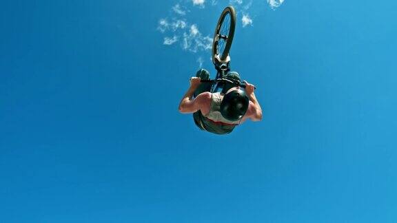 SLOMO男性摩托车起飞到空中做一个翻转与他的DJ自行车在阳光