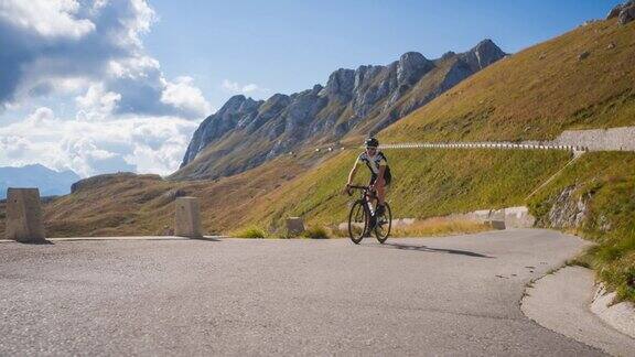 运动活跃的男子在风景优美的山路上骑自行车