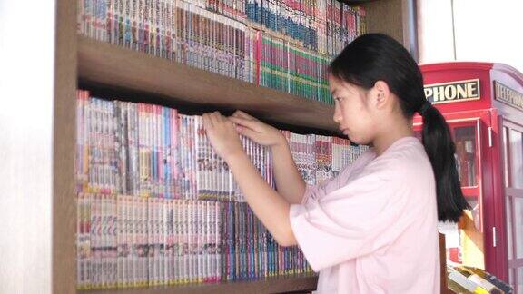 一个亚洲女孩在图书馆找到一本书4K