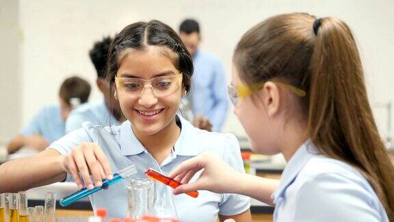 十几岁的女性STEM学校化学实验室合作伙伴进行实验