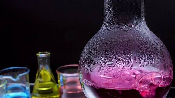 近距离酒精灯是烧瓶中沸腾的化学液体黑色背景是实验室玻璃器皿实验室研发理念