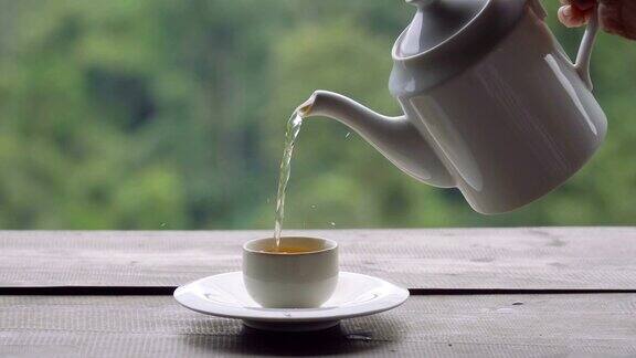 以茶田为背景倒热绿茶