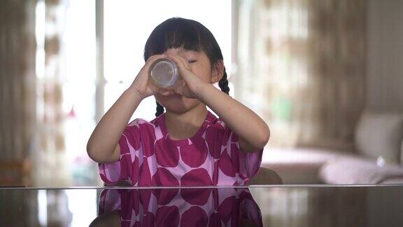 小女孩喝着一杯牛奶