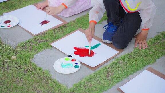 一群学生在学校花园的户外画板上涂色可爱的孩子们在小学学习如何用水彩画和画笔画艺术画享受创造性的有趣活动