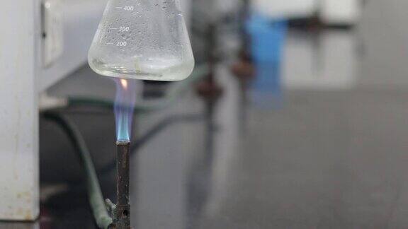在化学实验室用蓝色燃烧器火焰在锥形烧瓶中加热无色液体
