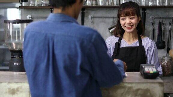 在一家当地的咖啡店里一位漂亮的女咖啡师正在为一位女顾客点单