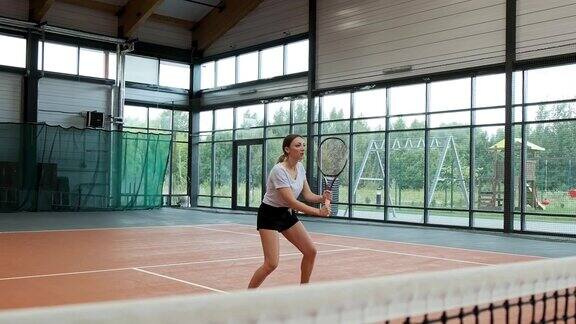 年轻女子用球拍打网球人打网球