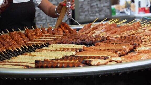 在一个民间节日里用烤肠、波兰熏肠、火腿肠、烤火串和猪肉轮流烤制