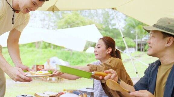 4K亚洲夫妇一起做早餐与朋友在森林山露营的早上
