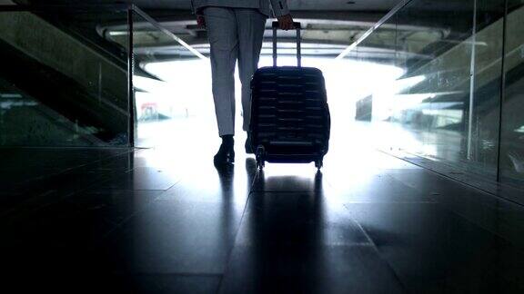 在机场拿着手提箱的商人的下层