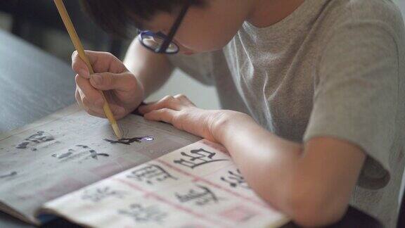 亚洲中国少年在家里练习中国书法