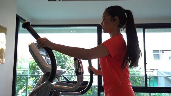 年轻女子在宾馆健身房的椭圆机上锻炼
