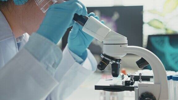 医学研究科学家在生物应用科学实验室的数字显微镜下进行DNA实验