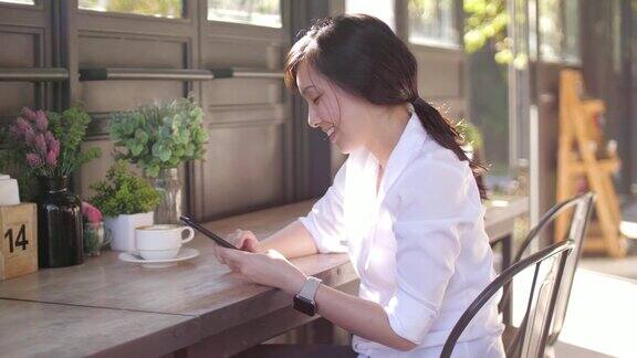 慢镜头年轻女子在咖啡馆使用手机