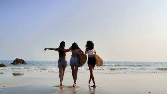 亚洲三个美丽的年轻女子冲浪女孩在沙滩上穿着比基尼和白色冲浪板体育cinemagraph