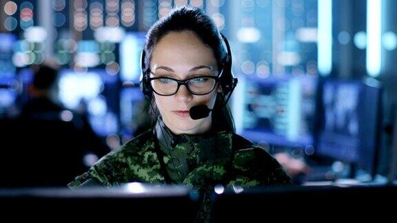 女军事技术支持专业人员给耳机指令她在监控室里和其他警官还有很多工作展示