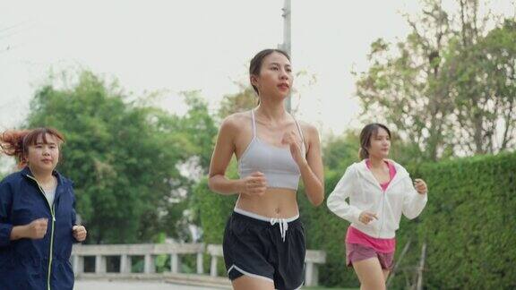 多种族团队年轻的亚洲运动女性穿着运动服早上在家里的花园公园跑步参加跑步俱乐部和户外运动