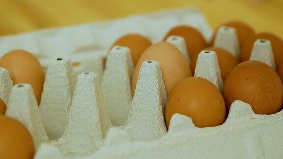 用手把包裹里的鸡蛋折出来接近灰色的鸡蛋纸盒与人把鸡蛋从纸盒