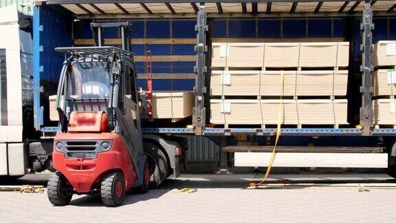 仓库卸货卡车把货物从卡车上卸到仓库叉车正在把货物从卡车运到户外仓库