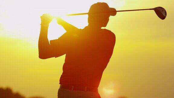 日落时分男性高尔夫球手在球道上开球