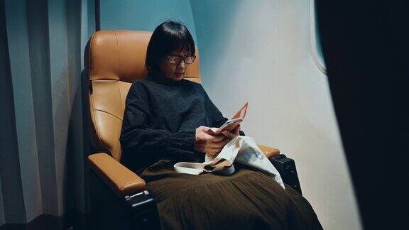 商务乘客在飞机上使用智能手机
