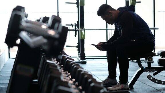 男人在健身房使用智能手机