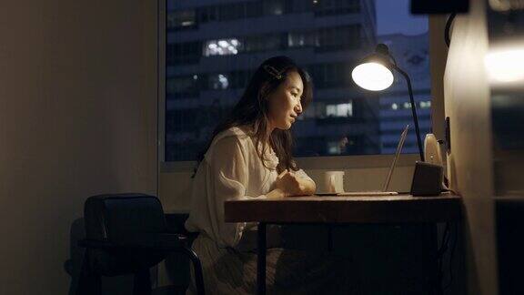 一名亚洲女企业家下班后还在自己的办公桌前加班涉及商业和金融概念