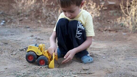 小男孩在玩玩具推土机