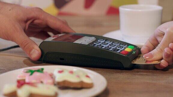在咖啡厅使用Pos终端支付订餐用芯片信用卡付账的女人