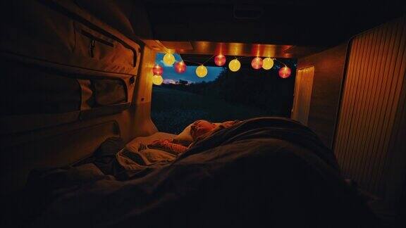 黄昏时分WS女人睡在停在乡间的一辆露营车里
