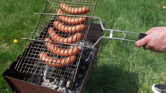 烧烤架为野餐做香肠热狗香肠在户外烤架上翻炒进行一次野餐