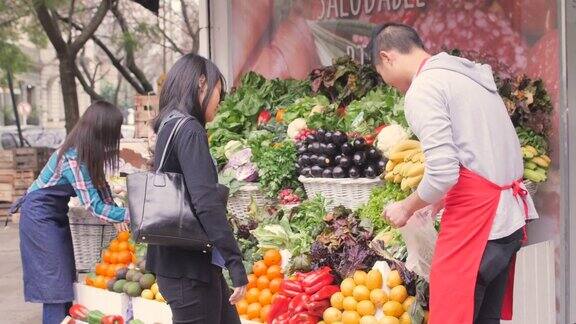 在亚洲市场上卖水果和蔬菜的亚洲推销员