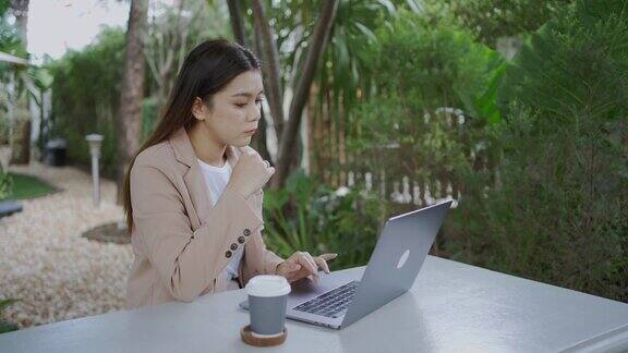 亚洲女人在咖啡馆用笔记本电脑