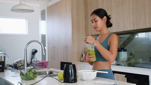 年轻的成年亚洲妇女在家里的厨房里制作健康的食物和饮料